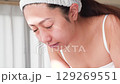 一位年輕的亞洲女子正在洗臉。 129269551