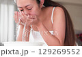 一位年輕的亞洲女子正在洗臉。 129269552
