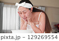 一位年輕的亞洲女子正在洗臉。 129269554