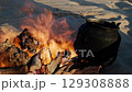 Iron kettle boiling over open campfire in the desert 129308888
