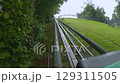 Exciting mountain coaster ride through lush greenery at local amusement park 129311505