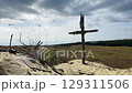a serene desert landscape with a wooden cross in a grassy area 129311506