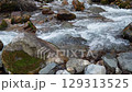 Slow motion video of flow of fast mountain shallow river with clean cold clear water with 25 fps. The stream is bubbling and splashing, creating bubbles of air when large stones hit its path 129313525