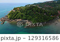 Aerial panorama of Ko Lanta island in Thailand with white sand beach, turquoise sea, rocky cliffs, small boats, and lush tropical hills - an exotic and popular holiday destination. 129316586
