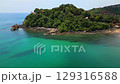 Aerial panorama of Ko Lanta island in Thailand with white sand beach, turquoise sea, rocky cliffs, small boats, and lush tropical hills - an exotic and popular holiday destination. 129316588