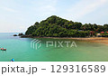 Aerial panorama of Ko Lanta island in Thailand with white sand beach, turquoise sea, rocky cliffs, small boats, and lush tropical hills - an exotic and popular holiday destination. 129316589