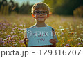 Child expresses gratitude in colorful flower field during a sunny day 129316707