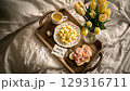 Delightful breakfast tray with flowers and heartfelt greeting for Mothers Day celebration 129316711