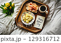 Delightful breakfast tray with flowers and heartfelt greeting for Mothers Day celebration 129316712