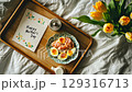 Celebratory breakfast in bed featuring toast, coffee, flowers, and a heartfelt message for Mothers Day 129316713