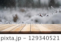 Creative interior concept. Empty wooden table top in focus with blur defocused falling snow bokeh landscape background. Template for product presentation. wallpaper banner clip mov 4K HD motion	 129340521