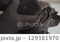 Thief stealing wallet and money from black leather bag 129381970