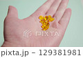 Male and gripping translucent omega 3 softgel capsules against blurred surface 129381981