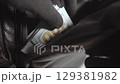 Thief stealing a stack of hundred dollar bills from black leather bag 129381982