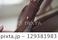 Hand adjusting leather handbag strap 129381983