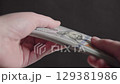 Hands exchanging a stack of one hundred dollar bills 129381986