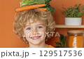 Small joyful boy holds fresh vegetables on his head, blending play with healthy eating  129517536