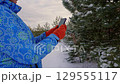 Female explorer navigating a snowy forest using a smartphone 129555117