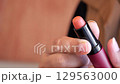 Woman holding a lipstick with copy space  129563000