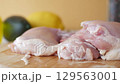 Raw Chicken Thighs Placed on a Cutting Board Alongside Fresh Fruits 129563001