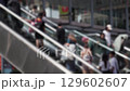 Crowd of Unrecognizable People on Escalator in Urban Setting 129602607