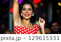 Dancer showcases vibrant red dress with white polka dots at summer travel destination, bringing joyful energy to the scene. Friends laugh and enjoy memorable moments during vacation. 129615331