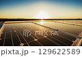 夕焼けの広大な太陽光パネル群：クリーンエネルギーソリューション 129622589