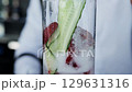Bartender prepares a delicious cocktail with lemonade, cucumber and strawberry, close-up. Slow motion, non-alcoholic 129631316