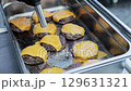 Beef burger patties with cheese in a tray on the table, close-up. Slow motion 129631321