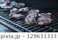 Pieces of juicy meat are grilled on a barbecue grill in the smoke. Slow motion 129631333