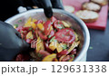 cooking vegetable salad with yellow and red tomatoes with parsley, close-up 129631338