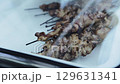 Fried chicken fillet on skewers under a lid, slow motion 129631341