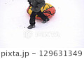 a boy climbs a hill and pulls a tubing tube behind him, slow motion 129631349