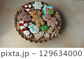 Gingerbread cookies with icing on a plate. Christmas food. Gingerbread man house. Top view 129634000