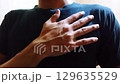 Hand on chest gesture symbolizing respect, sincerity, or oath-taking in blue shirt closeup Hand on chest gesture symbolizing respect, sincerity, or oath-taking in blue shirt closeup 129635529