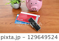 Bankbook, seal, and piggy bank lined up on a desk 129649524