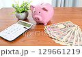 Financial image of a piggy bank, Japanese banknotes and a calculator 129661219
