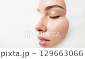The tranquil profile of a youthful female's face with closed eyelids, immersed in a soothing white liquid, captures a moment of purity and skincare indulgence. 129663066