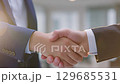 Close-Up of Business Professionals Shaking Hands in Office Setting 129685531