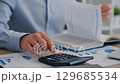 Business Professional Working with Calculator and Financial Documents 129685534