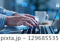 Hands Typing on Laptop with Digital Security Icons in Background 129685535