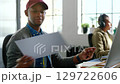 Digital agency, writing and notebook with employee and documents in startup, small business or planning company. Review, strategy and idea with young businessman working at desk in office building 129722606