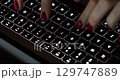 Female hands with red manicure are typing on keyboard 4k movie 129747889