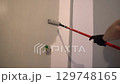 Painting walls with a paint roller for perfect wall painting. Roller movement from top to bottom. Grey paint on the surface. High quality 4k footage 129748165