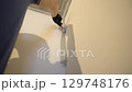 Painting a corner in a room. The painter paints the walls. The concrete walls are painted gray with a brush. High quality 4k footage 129748176