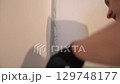 The process of painting walls in which the surface is painted with paint using a brush. For uniform application of paint. Apartment renovation. High quality 4k footage 129748177