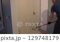 Painting walls with a paint roller for perfect wall painting. Roller movement from top to bottom. Grey paint on the surface. High quality 4k footage 129748179