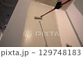 The repairman paints the walls with a pile roller for a perfect wall painting. Roller movement from top to bottom. High quality 4k footage 129748183