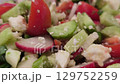 Fresh vegetable salad with cucumbers, radish, and cheese in bowl 129752259