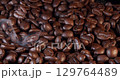 Close up of seeds of coffee. Fragrant coffee beans are roasted smoke comes from coffee beans. 129764489